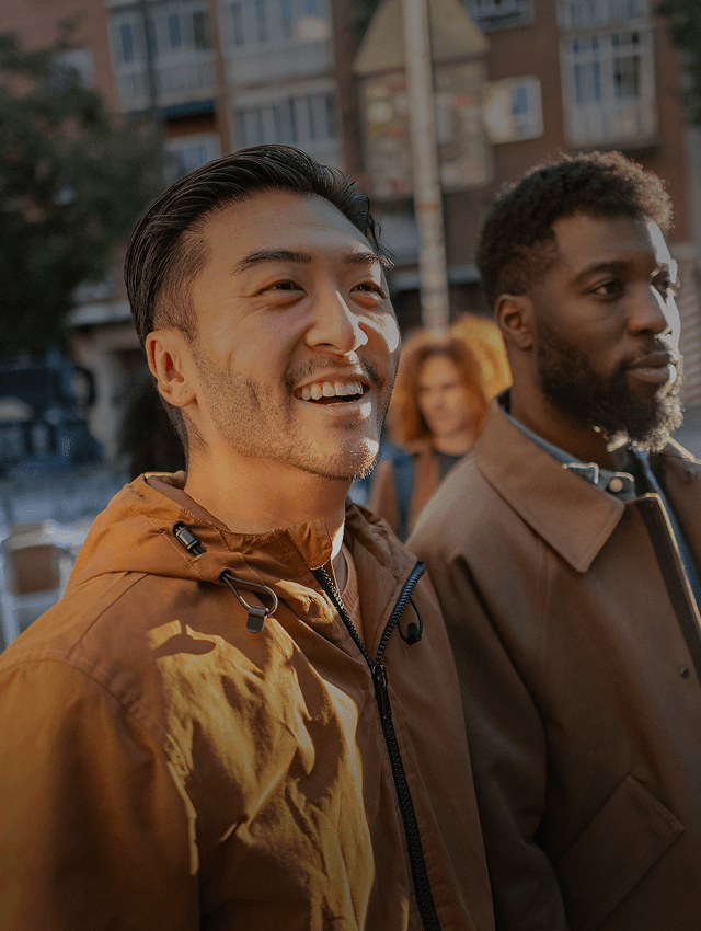 Amigos sonrientes caminan por una calle en un nuevo país.