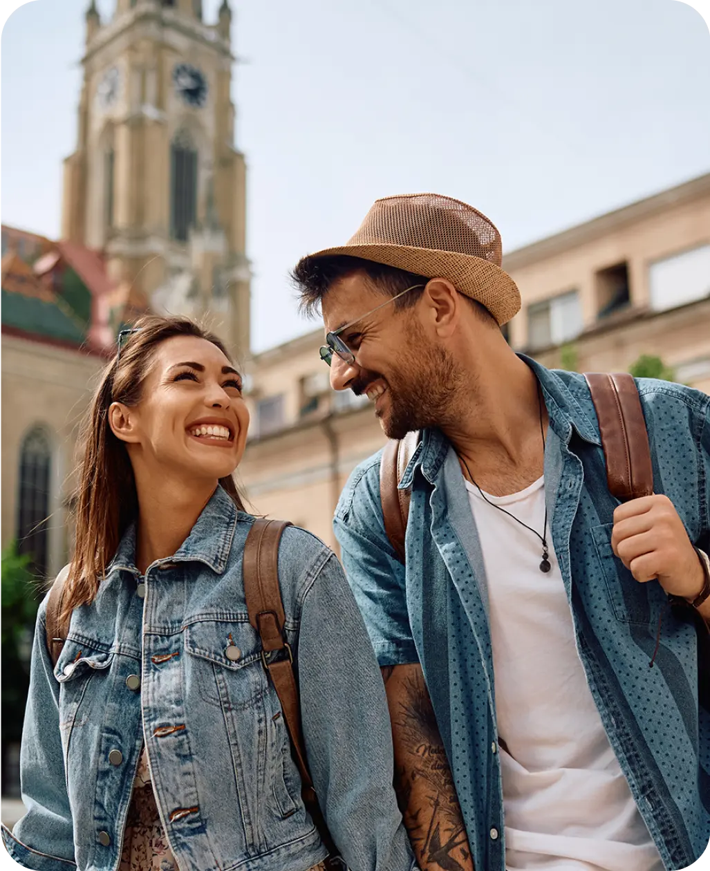 Una pareja sonriente paseando en el exterior representa el uso del idioma en el mundo real.