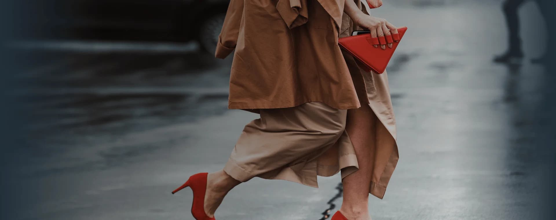 Una mujer bien vestida, con hermosos tacones altos rojos y un bolso rojo de moda, cruza la calle. Se superpone la frase francesa "bien habillé" con su traducción al español, "bien vestido".