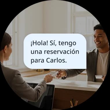 Two people having a conversation, with a speech bubble showing the Spanish phrase '¡Hola! SĂ, tengo una reservaciĂłn para Carlos,' illustrating a real-life dialogue mission.